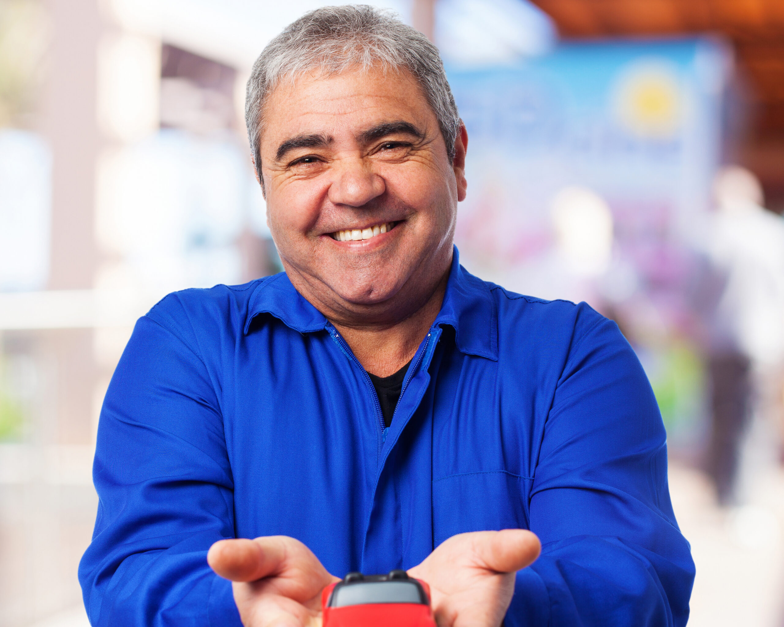 portrait of a mechanic holding a red car toy